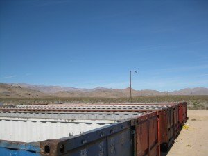 view of several shipping containers lined up outdoors, modified for use as a shrimp farm 