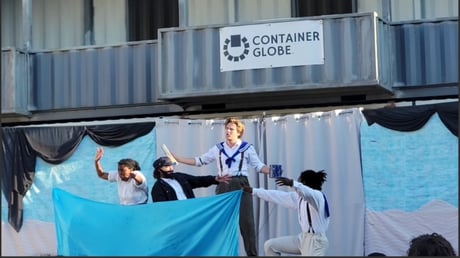 Modified shipping container theater stage during play