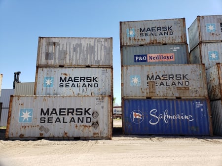 tall stacks of used shipping containers